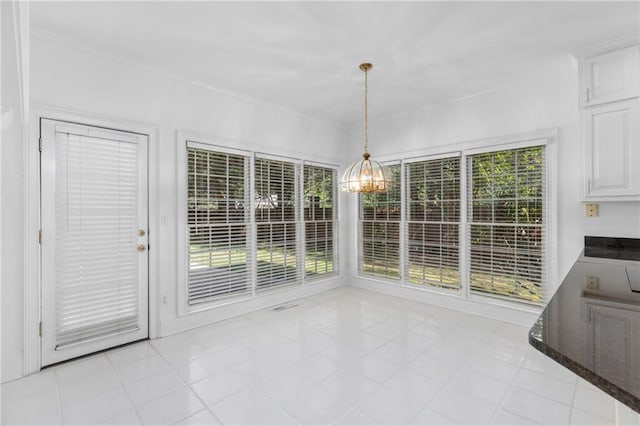 unfurnished dining area featuring light tile patterned flooring and a chandelier