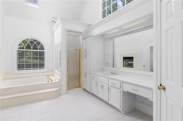 bathroom with a wealth of natural light, independent shower and bath, tile patterned flooring, and vanity