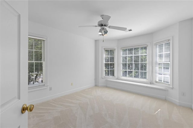 empty room featuring light colored carpet and ceiling fan