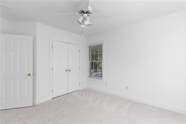 unfurnished bedroom featuring a closet, ceiling fan, and light carpet