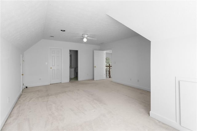 bonus room with ceiling fan, a textured ceiling, light carpet, and lofted ceiling