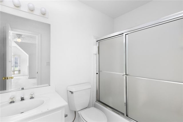 full bathroom featuring ceiling fan, toilet, vanity, and shower / bath combination with glass door