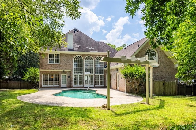 back of house with a lawn, a fenced in pool, a patio area, and french doors