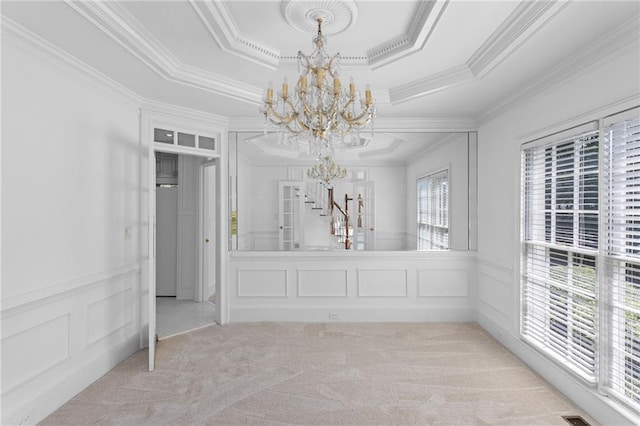 unfurnished dining area featuring a wealth of natural light, a notable chandelier, a tray ceiling, and light colored carpet