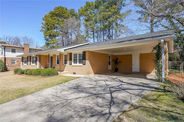 ranch-style house with driveway, crawl space, a front lawn, a carport, and brick siding