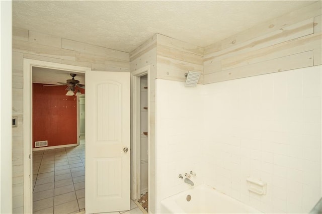 bathroom with wood walls, a textured ceiling, tile patterned flooring, and ceiling fan