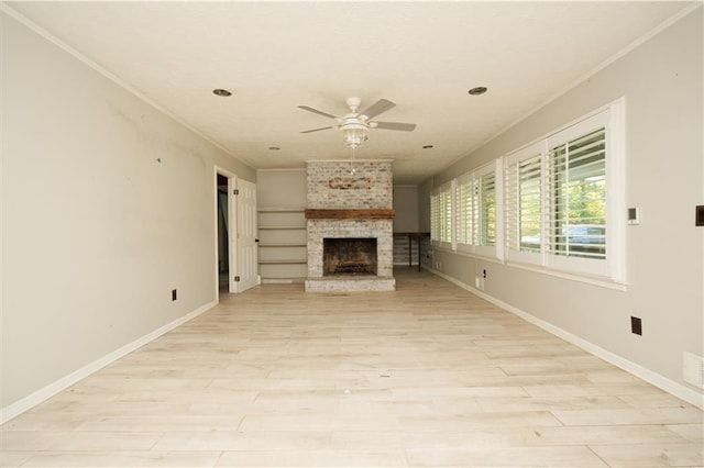 unfurnished living room with crown molding, ceiling fan, light wood-type flooring, and a brick fireplace