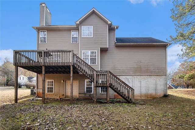 rear view of property with a deck, a yard, and central air condition unit