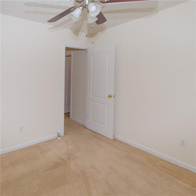 unfurnished room featuring ceiling fan and light carpet