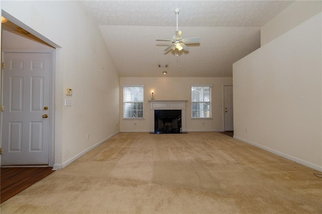 unfurnished living room featuring light carpet, vaulted ceiling, and ceiling fan