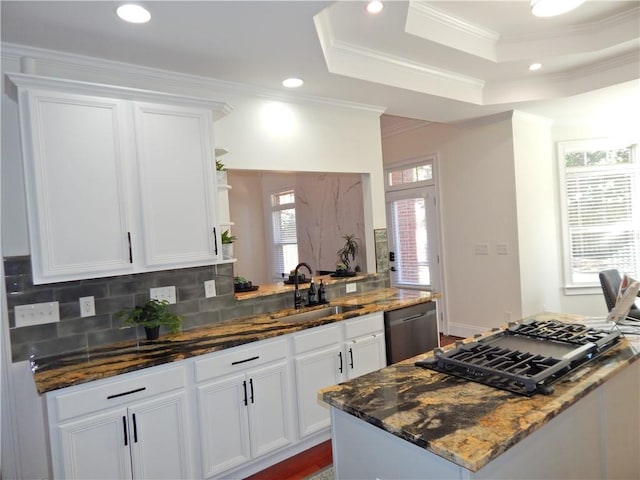 kitchen featuring white cabinetry, a sink, and a peninsula