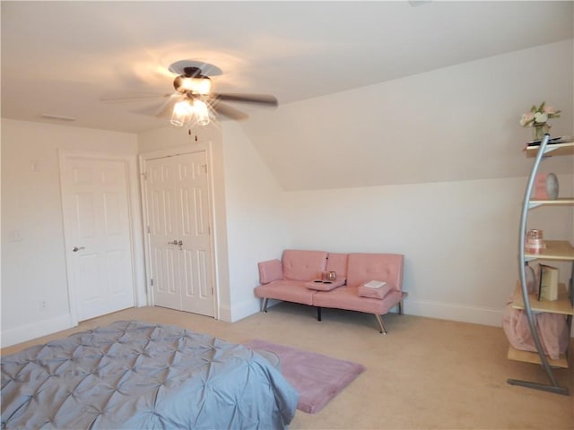 bedroom featuring ceiling fan, light colored carpet, baseboards, vaulted ceiling, and a closet