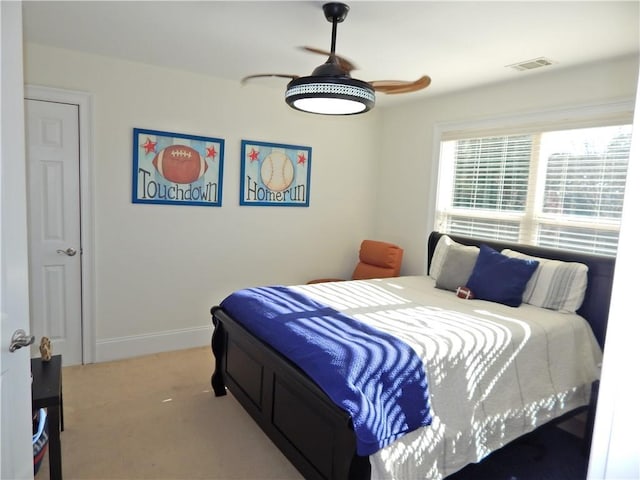 bedroom featuring baseboards, visible vents, ceiling fan, and light colored carpet