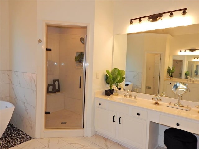 bathroom featuring a sink, a freestanding bath, marble finish floor, double vanity, and a stall shower