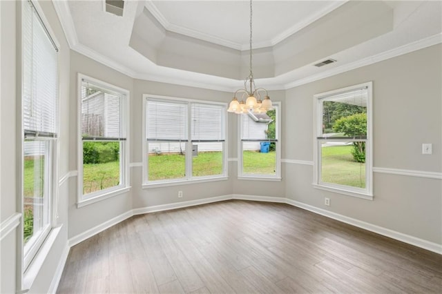 interior space featuring crown molding, a raised ceiling, wood finished floors, and a notable chandelier