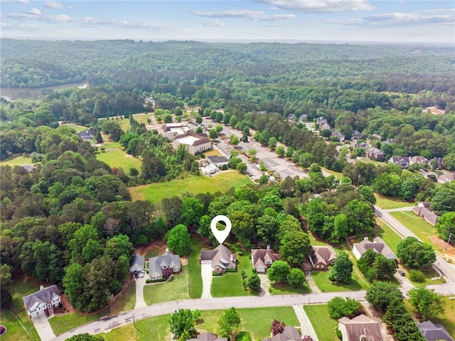 drone / aerial view featuring a residential view and a forest view