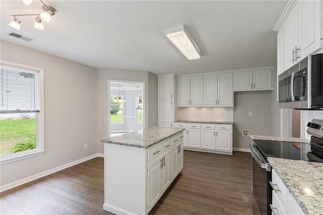 kitchen featuring appliances with stainless steel finishes, dark wood finished floors, white cabinetry, and visible vents