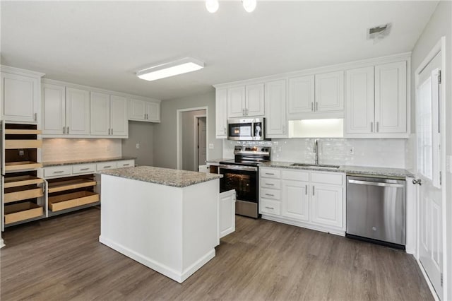 kitchen with stainless steel appliances, dark wood-style floors, a sink, and white cabinetry