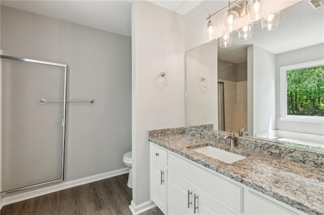 bathroom featuring vanity, toilet, baseboards, a shower stall, and wood finished floors