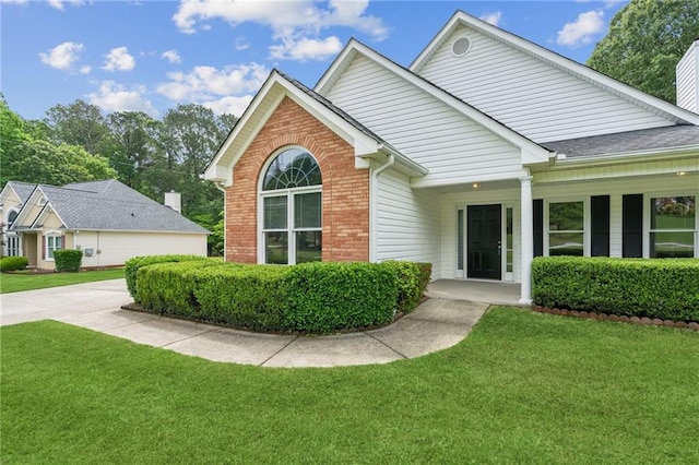 view of front facade with a front yard and brick siding