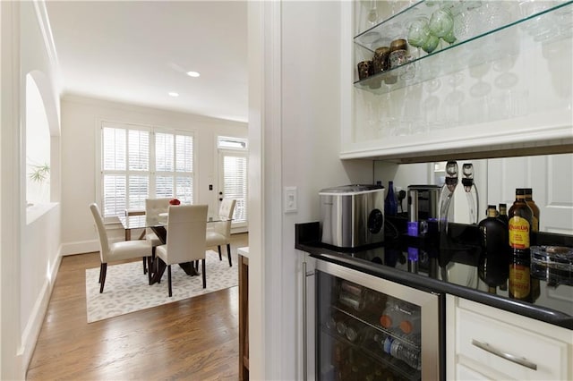 bar featuring wine cooler, crown molding, and dark hardwood / wood-style floors