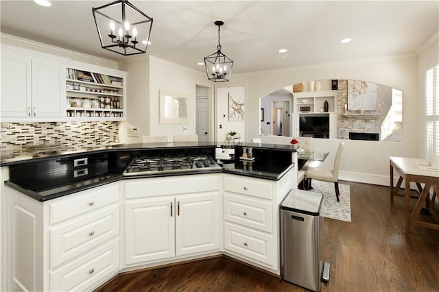 kitchen with white cabinetry, crown molding, decorative light fixtures, and stainless steel gas cooktop