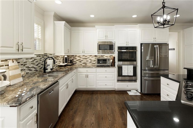 kitchen featuring stainless steel appliances, white cabinetry, hanging light fixtures, and sink