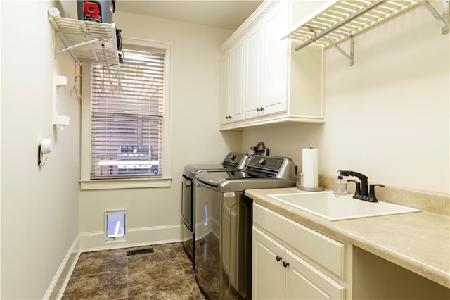 laundry room featuring cabinets, sink, and washing machine and dryer