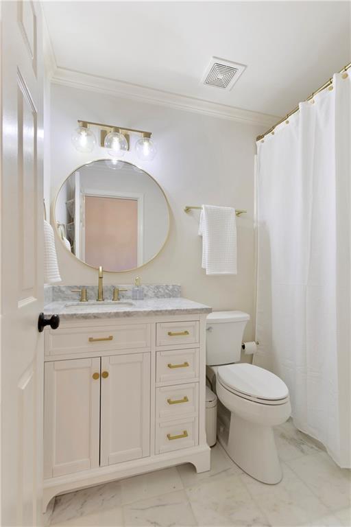 bathroom with vanity, toilet, and ornamental molding