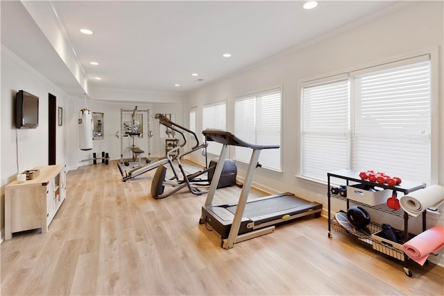 exercise room with light wood-type flooring and ornamental molding