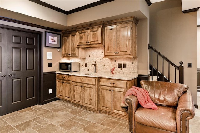 kitchen featuring decorative backsplash, sink, and ornamental molding