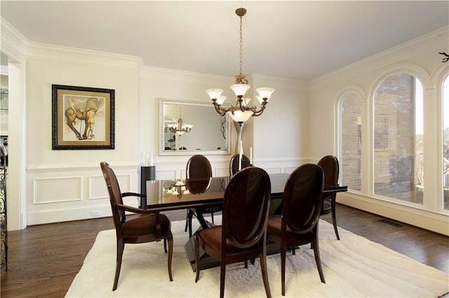 dining space featuring a chandelier, dark hardwood / wood-style flooring, and ornamental molding