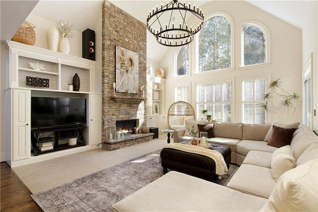 living room with a fireplace, high vaulted ceiling, and a notable chandelier