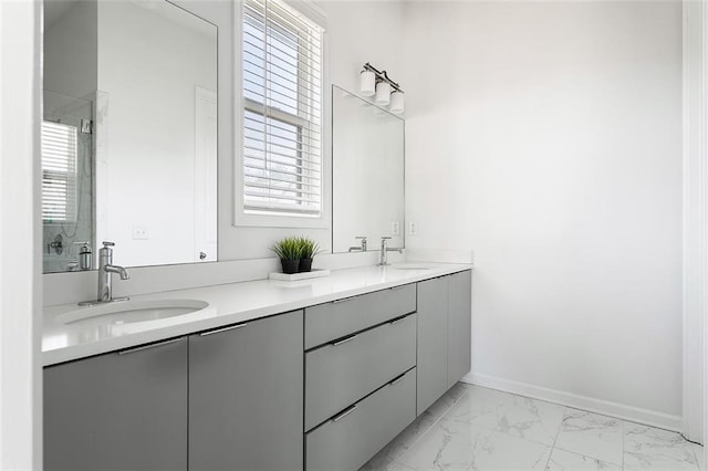 full bath with marble finish floor, a sink, and a healthy amount of sunlight
