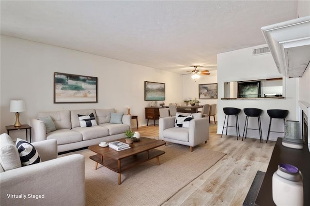 living room with ceiling fan and light hardwood / wood-style floors