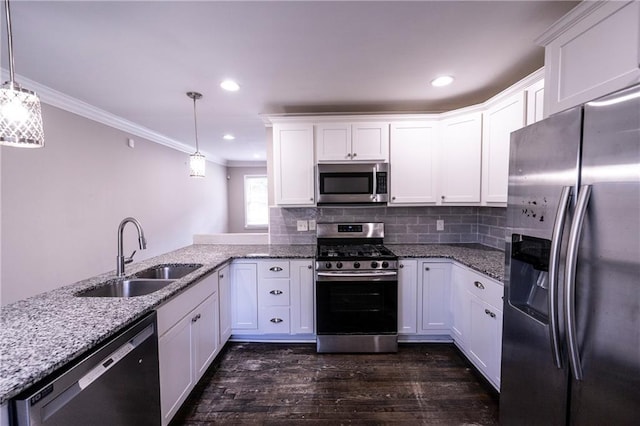 kitchen with pendant lighting, sink, kitchen peninsula, white cabinetry, and stainless steel appliances