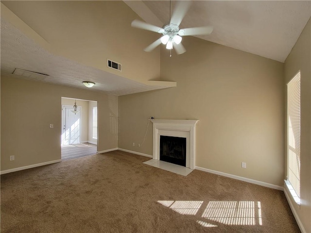 unfurnished living room featuring carpet, ceiling fan with notable chandelier, a healthy amount of sunlight, and vaulted ceiling