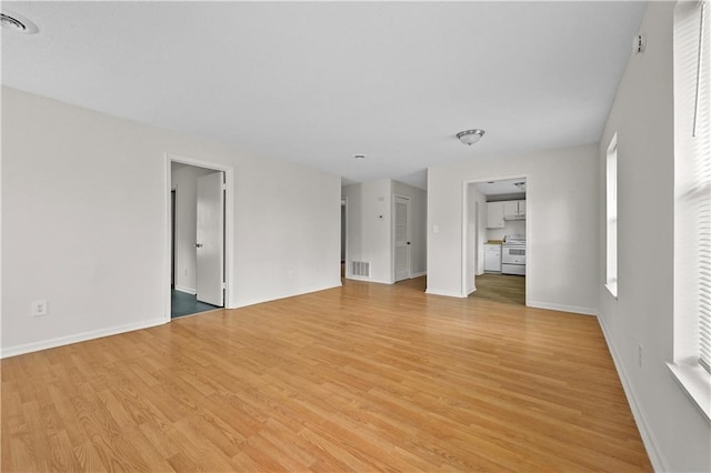 unfurnished living room featuring light wood-style floors, visible vents, and baseboards