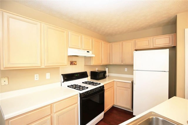 988 Vintage Pointe Dr, Lawrenceville, GA 30044 - kitchen featuring light countertops, freestanding refrigerator, under cabinet range hood, black microwave, and gas stove