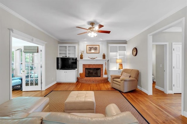 living room with crown molding, a ceiling fan, baseboards, and wood finished floors
