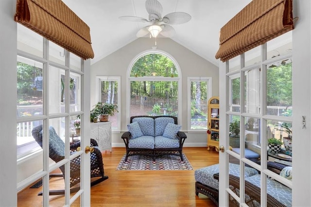 sunroom featuring a deck, wood finished floors, a wealth of natural light, and vaulted ceiling