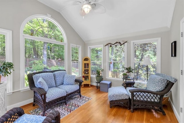 sunroom with a healthy amount of sunlight, baseboards, vaulted ceiling, and wood finished floors
