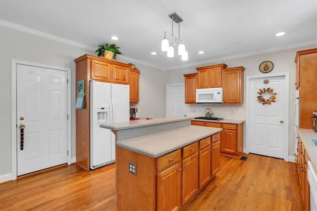 kitchen with white appliances, recessed lighting, light wood-type flooring, and a center island