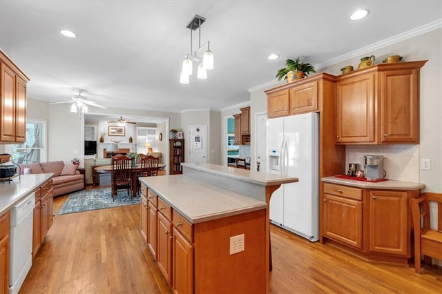 kitchen featuring a kitchen island, white appliances, light countertops, a ceiling fan, and light wood-style flooring