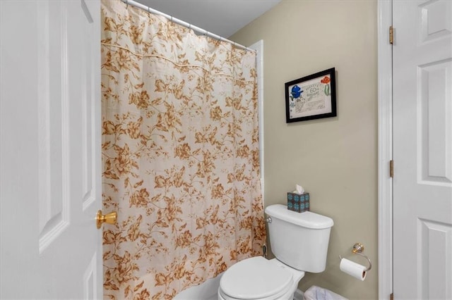 bathroom featuring curtained shower and toilet