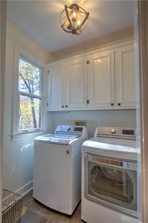 laundry room featuring washer and dryer and cabinets