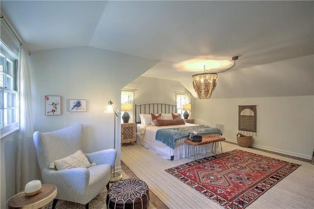 bedroom featuring vaulted ceiling, carpet floors, and an inviting chandelier