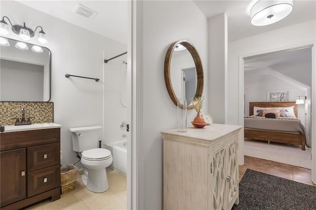 full bathroom with tile patterned flooring, bathing tub / shower combination, toilet, decorative backsplash, and vanity