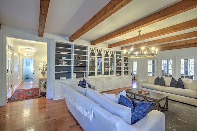 living room featuring beam ceiling, an inviting chandelier, and hardwood / wood-style floors