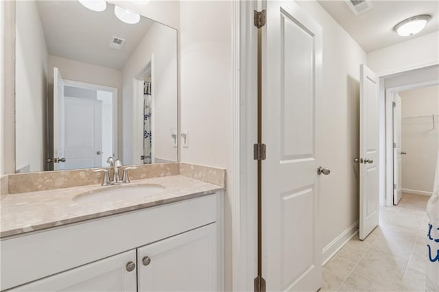 bathroom featuring vanity, baseboards, and tile patterned flooring
